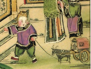 A child playing with a toy ox-wagon. He wears a tiger hat.