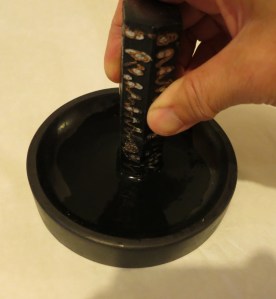 Grind the ink in a circular motion with the end flat on the surface